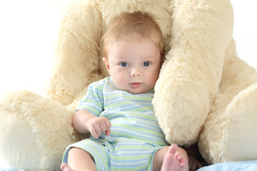 Baby and teddy bear looking at you