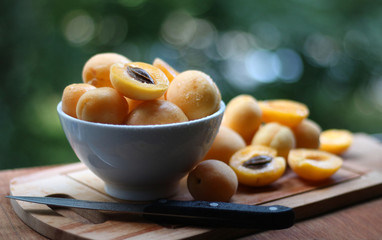 Apricots in a white plate on a wooden surface