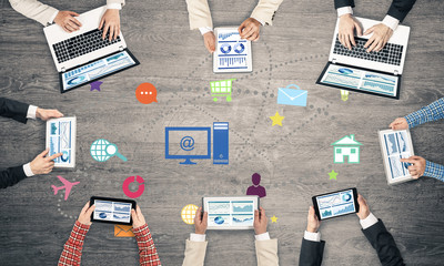 Top view of businesspeople sitting at table and using gadgets