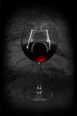A glass of red wine taken in a low key.