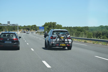 Sur l'autoroute : voiture équipée d'un porte-vélos à l'arrière.