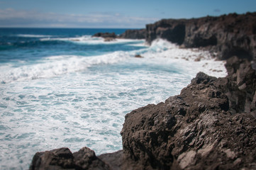 Fototapeta na wymiar Lanzarote volcanic coastline with oceanic waves tilt shift effect