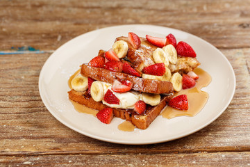 Dessert routons with strawberries, bananas and ice cream with honey
