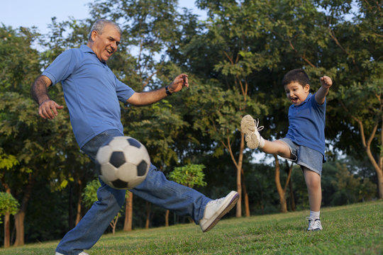 Grandfather and grandson playing soccer