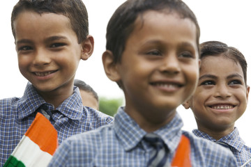 Portrait of a school boy holding the Indian flag 