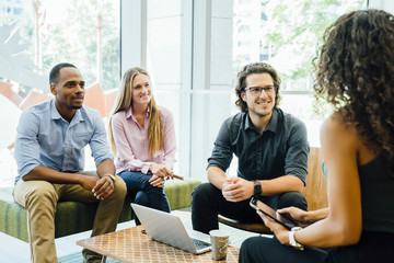 Diverse group of coworkers meeting in modern office space