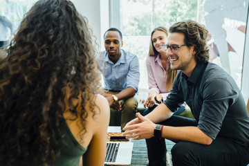 Diverse group of coworkers meeting in modern office space