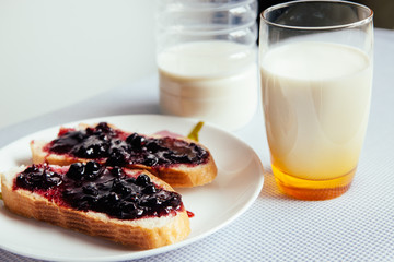 Breakfast with milk and bread with jam 
