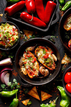 Grilled sweet peppers poppers stuffed with cheese and herbs, mix  delicious appetizers on a black background, top view