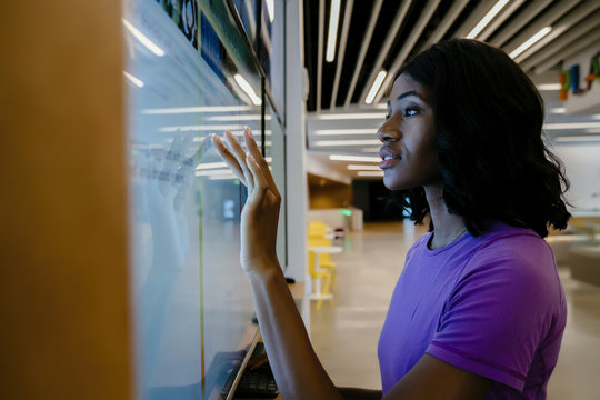 Woman touching large computer screen monitor