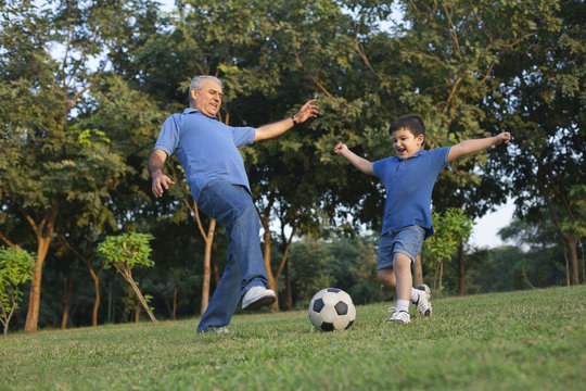 Grandfather and grandson playing soccer