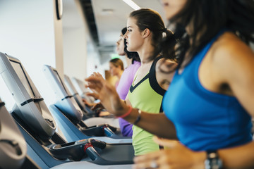 Fototapeta na wymiar Group of women running on treadmills at a gym