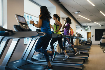 Group of women running on treadmills at a gym