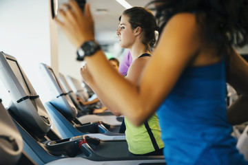 Fototapeta na wymiar Group of women running on treadmills at a gym