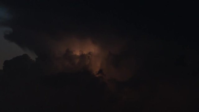 Time lapse clip of evening fluffy curly rolling clouds with lightning