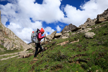 Fototapeta premium young woman with backpack hiking in mountains