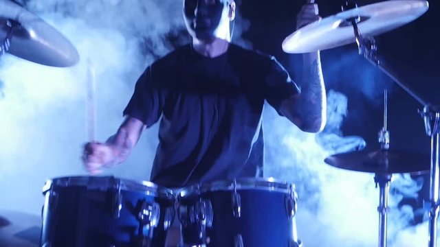 Concert rock band performing on stage with drummer. Music video punk, heavy metal or rock group. Slow motion instrument playing