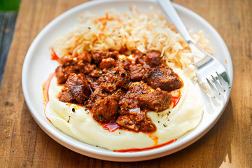 Mashed potatoes with pork hungarian goulash with paprika and side sour cabbage salad  