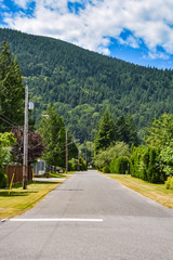Asphalt road of rural town street leading toward a mountain