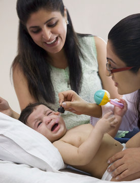 Doctor putting drops into a babies mouth 