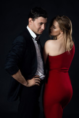 Young couple in evening gown in black background