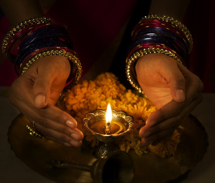 Hands cupped around a diya 