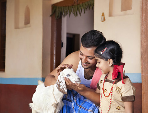 Father showing a goat to his daughter 