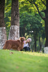 Girl and Golden Retriever playing in the grass