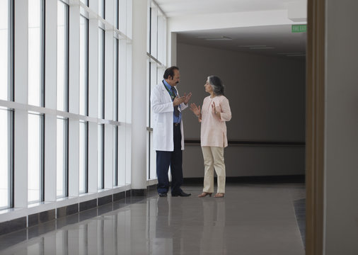 Doctor discussing patient care in hospital corridor