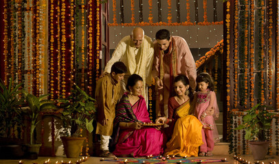 Family arranging diyas 