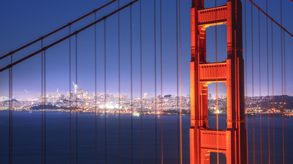 First tower of the Golden Gate Bridge and San Francisco Downtown in the night