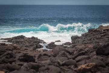 Fototapeta na wymiar Tilt shift effect of oceanic waves against the Boca de Abaco volcanic rocks coast, Lanzarote, Canary Island