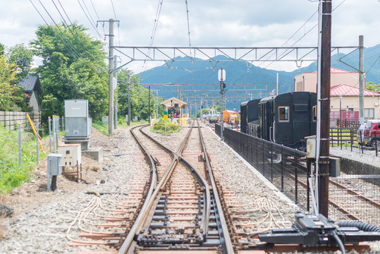 Railway train station in countryside of Japan with mountain background.