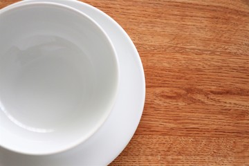 Empty white bowl and plate staying on table background
