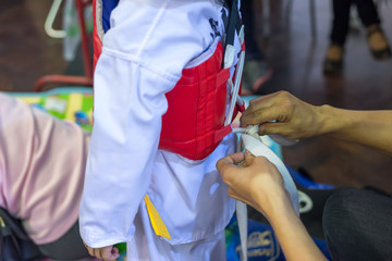 Young Taekwondo athletes dress up for fighting in contest.