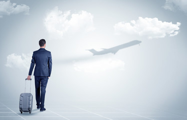 Obraz premium Businessman with luggage look to an airplane