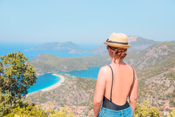 Girl is standing on top of the rock and enjoying the view - oludeniz Turkey