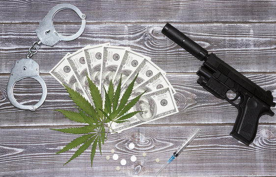 Marijuana, dollars, syringe, tablets, handcuffs, pistol with a silencer.