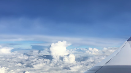 Fototapeta na wymiar Dramatic atmosphere panorama view of blue sky and clouds looking from aircraft window.