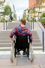Obraz premium disabled man in wheelchair in front of stairs