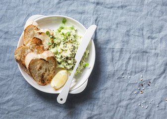 Healthy vegetarian snack - mashed avocado and toast bread on blue background, top view