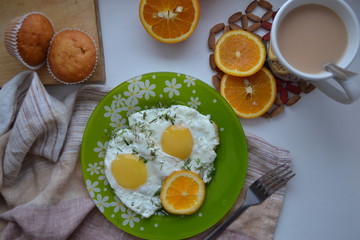 
Breakfast. Fried eggs with orange, cocoa and cupcakes.