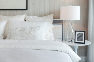 Luxury style bedding with puffy pillow and white table lamp in bedroom