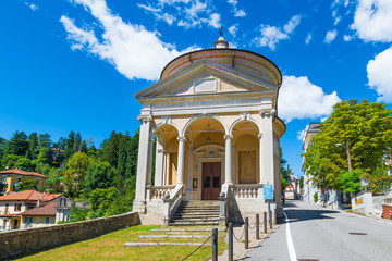 Fototapeta na wymiar Sacro Monte of Varese (Santa Maria del Monte), Italy, starting point for the Via Sacra with 14 chapels that leads to medieval village. In the foreground the Immaculate church on a beautiful summer day