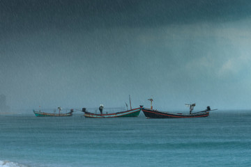 Fishing boat on the sea with raining.