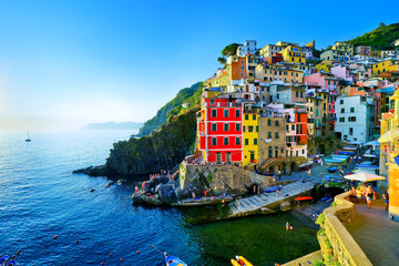 Riomaggiore village along the coastline of Cinque Terre area at sunset in Italy.