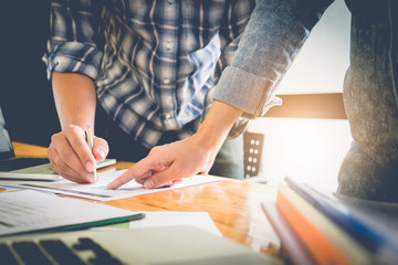 Close up business man and woman hand pointing at business document financial paper during discussion at meeting. Group support concept.