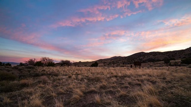 Time lapse of colorful sunrise across grassy desert