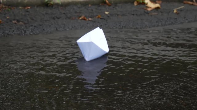 White paper ship in a rain stream