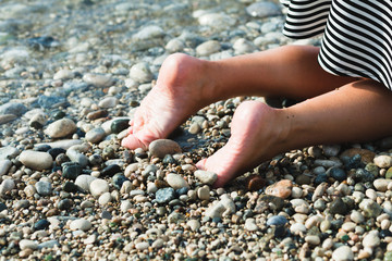 The feet of a young woman on the beach